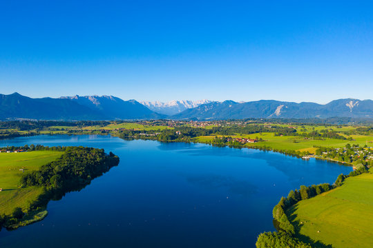 Scenic view of Riegsee lake and green landscape against clear blue sky, Germany