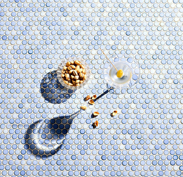 Directly above shot of martini and pistachios served on table