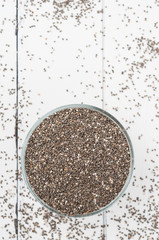 Chia seeds in a bowl on a white wooden background