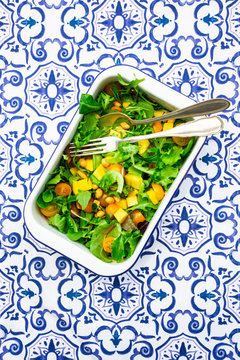 Directly above shot of vegetable salad with cutleries in bowl on patterned table