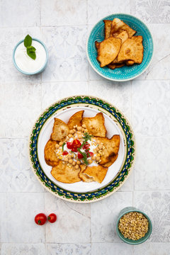Directly above shot of Fatteh on plate with yoghurt and flatbread in bowl
