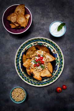 Bowl of Levantine fatteh, with flat bread, tomatoes and chickpeas
