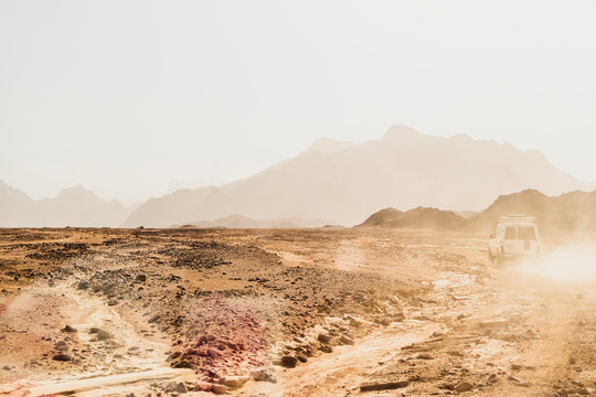 Off-road vehicle moving on arid landscape against clear sky during sunny day at Suez, Egypt