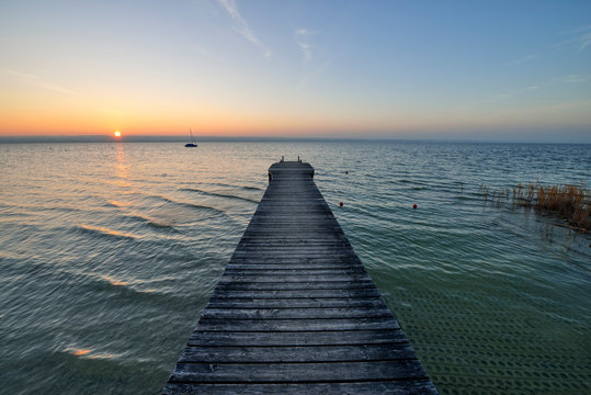 Sunset on wooden jetty over lake Ammersee Bavaria, Germany