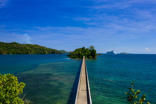 High angle view of empty footbridge leading towards island against blue sky, during sunny day Samana peninsula, Dominican Republic