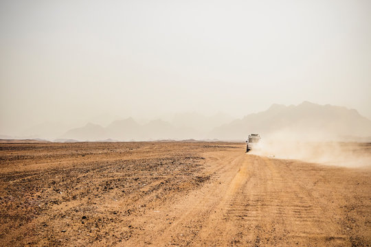 Off-road vehicle moving on arid landscape against clear sky, Suez, Egypt