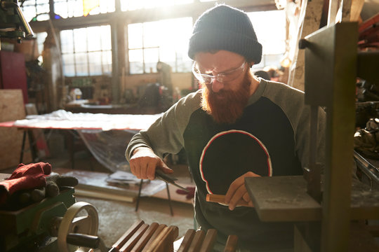 Man making knives in a workshop - Powered by Adobe