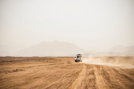 Off-road vehicle moving on arid landscape against clear sky during sunny day, Suez, Egypt