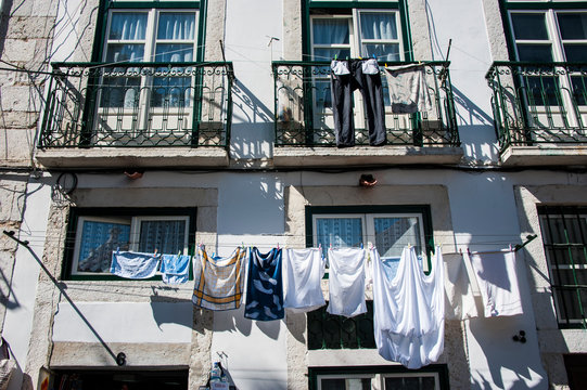 Low angle view of clothes hanging against window outside apartment, Lisbon, Portugal