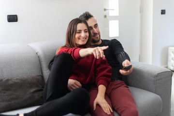 Obraz premium Couple watching a movie together on a couch