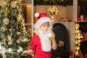 Fototapeta na wymiar Greeting Christmas card. Portrait of Santa Claus Drinking milk from glass and holding cookies. Santa Claus holding Christmas cookies and milk against Christmas tree background.