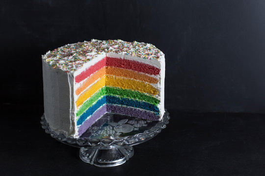 Close-up of rainbow cake against wall in studio