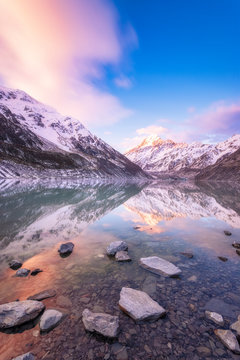 New Zealand, South Island, Rocky shore of Hooker Lake with Mount Cook and Hooker Glacier in background