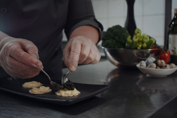 cook makes sandwiches with black caviar.