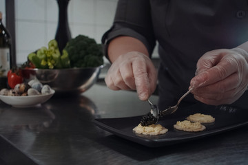 cook makes sandwiches with black caviar.