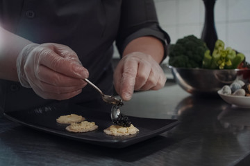 Fototapeta na wymiar cook makes sandwiches with black caviar.