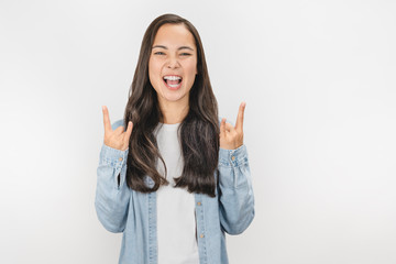 Young woman over isolated white background making rock gesture