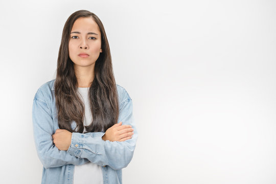 Portrait of angry woman standing with arms crossed on white background