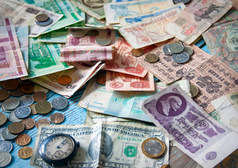 Close-up of old multi-colored banknotes and coins of different countries.