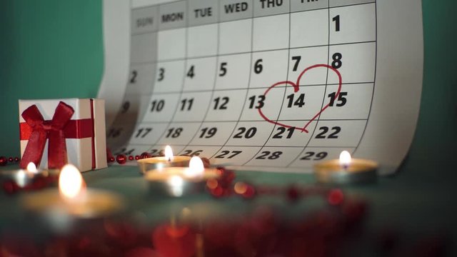 camera movement, calendar circled by the date of Valentine's day with a red marker, candles are burning, romance and gifts.