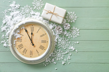 Clock, gift, snow and decor on wooden background. Christmas countdown concept