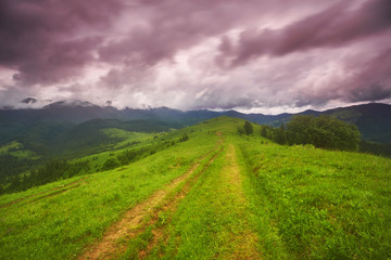 composite landscape. fence near the cross road on hillside meadow in mountains.