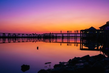 Naklejka premium wooden pier at the sea with beautiful bloody sunset. sunset seascape at a wooden jetty. Wood bridge