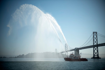 Naklejka na ściany i meble Fire Boat demo on the San Francisco Bay with Bay Bridge
