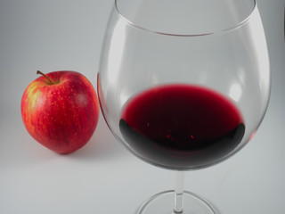 Glass of red wine and a red apple