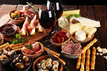 Italian antipasti wine snacks set. Cheese variety, Mediterranean olives, seafood salad, Prosciutto...