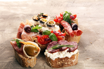 Appetizers table with italian antipasti snacks and wine in glasses. Brushetta or authentic traditional spanish tapas set, cheese variety