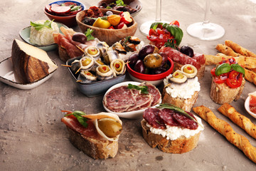 Appetizers table with italian antipasti snacks and wine in glasses. Brushetta or authentic traditional spanish tapas set, cheese variety