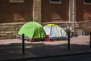 Homeless tents on street tent camp. Homeless man sleeping in shacks