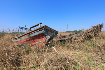 Fototapeta premium The broken wooden boat is on land