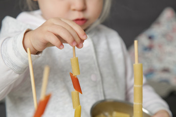 Fine motor pasta threading activity for kids. An easy and fun tower building challenge that works on fine motor skills as well as hand eye coordination.