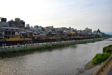 Views of the Kamo river during sundown, with locals enjoying the spring air, Kyoto, Japan