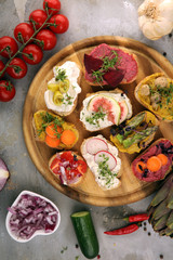 Assorted bruschetta with various toppings. Appetizing bruschetta or brie crostini. Variety of small sandwiches. Mix bruschetta on table
