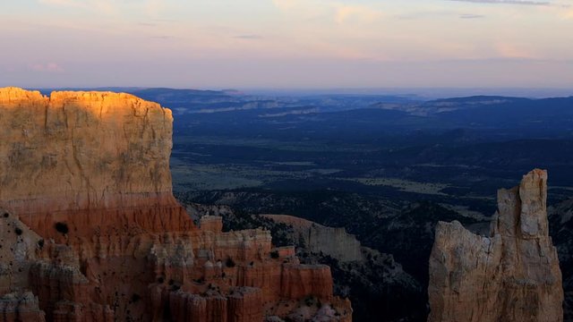 Paria view overlook of orange cliff rock in Bryce Canyon National Park in Utah at dark sunset timelapse of sunlight on formation