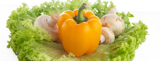Champiñones y pimiento morron, sobre unas hojas de lechuga con fondo blanco