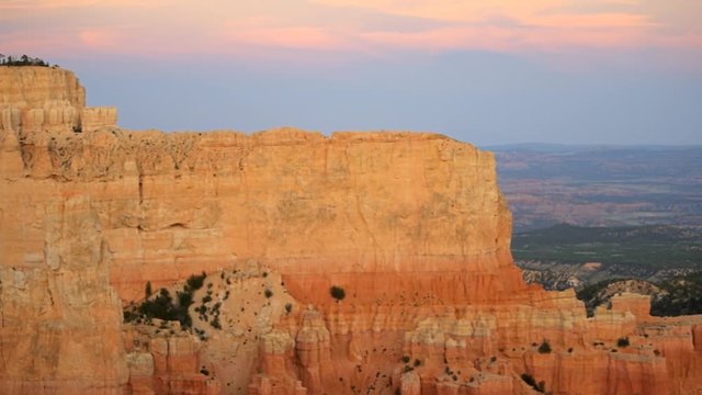 Paria view overlook panning of orange pink cliff rock hoodoos in Bryce Canyon National Park in Utah at dark sunset twilight and sunlight on formation