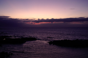 Fototapeta premium Sunset from a cove that forms a small beach