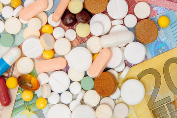 Money and pills. Pills of different colors on money. medicine concept. Euro cash