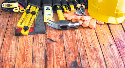 Construction tools in toolbelt on wooden background. Maintenance concept.