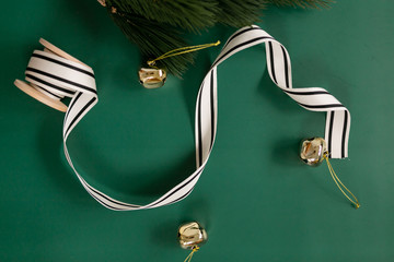 Styled Christmas flat lay with ribbon, spool, gold bells, and pine needles