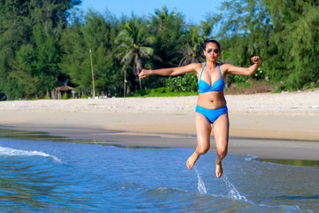Fototapeta premium Woman sexy and bikini blue jump on wave at beach