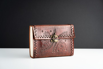 Brown leather notebook journal, stitched and embossed with metallic latch and details on textured leather.