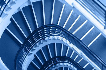 Fototapeta premium Classic Blue background made for Old blue spiral staircase inside an old house. Color of the Year 2020.