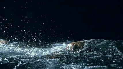 Slow motion of waves on dark water surface with play of flecks of bright light close up. Amazing dramatic natural background. Shooting with 180fps. Epic mystical and magic night view. Crystal clear