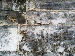 Abstract texture of mossy, porous, cracked and weathered sandstone walls. Wall texture can be used as a wall frame and wall background. Dirty and Old sandstone wall texture background.