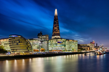 London's City Hall and modern skyscrapers at nightfall